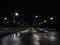 Night view of the roads going into the distance, with fences on the sides and illuminated by many lights