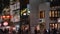 Night view of stores illuminated by neon signs on Omotesando avenue.