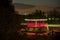 Night view of sun shelter in red colors with iconic Poolbeg Generating Station CCGT chimneys, Dublin Waste to Energy, Blackrock