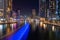 Night view to Dubai Marina panorama, reveals Pier 7, skyscrapers, speed boat light trails and beautiful bridge.