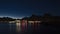 Night view of village SvolvÃ¦r, Lofoten, Norway with illuminated buildings reflected in the calm water, wooden stockfish racks.