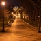 Night winter city park with row of lanters and benches. Park path in perspective. Copy space