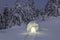 Night winter mountain landscapes. Igloo stands on the snowy lawn. House with light. Location place the Carpathian mountains.