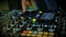 Nightclub DJ adjusting controls, twisting toggle on professional soundboard