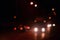 Nights lights of the big city, the blurred night avenue with bokeh traffic lights and headlights of the approaching car