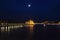 Nightscape city view of Budapest parliament under the moon lit cloudy sky and water reflection