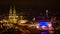 Nighttime Cologne Landscape with Bright Lights on Cathedral, TV Tower, and Hohenzoller Bridge