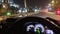 Nighttime driving concept with illuminated dashboard and blurry city traffic lights from driver perspective on a city road or