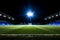 Nighttime magic enchanting soccer pitch shines in empty stadium under captivating lights.