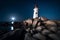 Nighttime Shadows: A Long Exposure of a Rotating Lighthouse Beam by the Sea