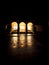 Nighttime shot of arched building with reflections in street.