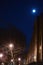 Nighttime shot of the moon, street lamps, and building facade in Harlem, New York, NY, USA