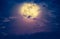 Nighttime sky with clouds and bright full moon. Vintage effect t