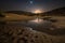 nighttime stars and moon reflected in the desert sand