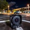 Nighttime Surveillance Camera Monitoring Parking Lot with Cityscape Background