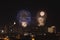 Nighttime view of a busy cityscape with a spectacular display of fireworks in the sky