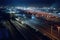 nighttime view of railway yard, with train engines and cars illuminated by bright lights