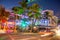 nightview to ocean drive with art deco hotels and restaurants in the art deco district and people having party