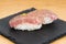 Nigiri of heat-burned kobe beef dressed with mustard, served on a square plate of slate