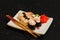 Nigiri Sushi set on white plate on black background. Japanese food. Asian tasty dinner.