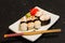 Nigiri Sushi set on white plate on black background. Japanese food. Asian tasty dinner.