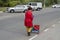 Nikolaev, Ukraine - October 24, 2020: an adult female janitor cleans fallen leaves in parking lot