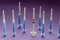 Nine different syringes stand upright