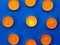 Nine mango-scented candles lie in a circle on a blue background, with one lighted candle in the center