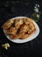 Nine pork pies on a white plate on a black background