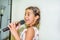 Nine year old girl singing with microphone