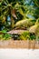 Nipa hot cottage over the fence with white sand beach on the tropical island