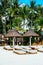 Nipa hut sun shade with bamboo sunbeds on white coral sand beach