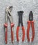 Nippers, adjustable wrench, pliers on a gray concrete background. Top view