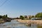 Nisava river and fortress with a bridge in the distance and quay promenade on summer sunny day