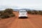 Nissan Almera driving dusty red road