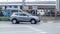 Nissan Qashqai moves fast on the highway. Gray Nissan Rogue Sport driving fast on the street with industrial district background,