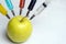 Nitrates, pesticides, fungicides and other chemicals are injected into a green apple with a syringe. Non-GMO and natural