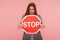 No access, way prohibited! Portrait of bossy brunette woman holding red traffic stop symbol, warning of danger