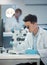 No better time than now. a young male technician analysing samples using a microscope.