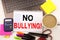 No Bullying text in the office with surroundings such as laptop, marker, pen, stationery, coffee. Business concept for Bullies Pre