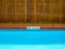 No diving sign and pool depth sign on pool edge on outdoor swimming pool on wooden fence background