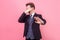 No, don`t want to look! Portrait of frustrated man in tuxedo showing stop gesture and hiding eyes. studio shot isolated on pink