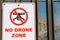 No drone zone warning sign on perimeter fence wall