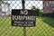No dumping violaters will be prosecuted sign on metal fence