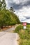 No entry for motor vehicles, cycling only allowed. Storm clouds over forest road. Closed entrance to the forest. Road sign