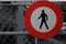 No entry or no access sign with a silhouettes of a person on a white circular ground with red circle around.