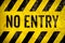 NO ENTRY warning sign stencil with yellow and black stripes painted over concrete wall cement texture background.