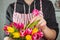 No face young man making spring bouquet using tulips. Online self-education of floristry. Learning flower arranging. Flowers