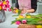 No face young man making spring bouquet using tulips. Online self-education of floristry. Learning flower arranging. Flowers