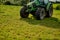 No farm is complete without a tractor. High angle shot of a green tractor on an open piece of farmland.